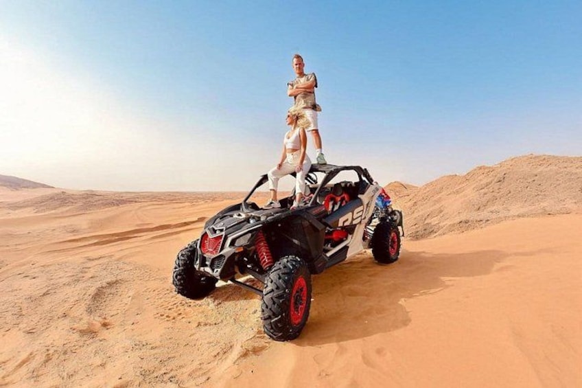A quad bike in a desert with sand dunes in the background. 3