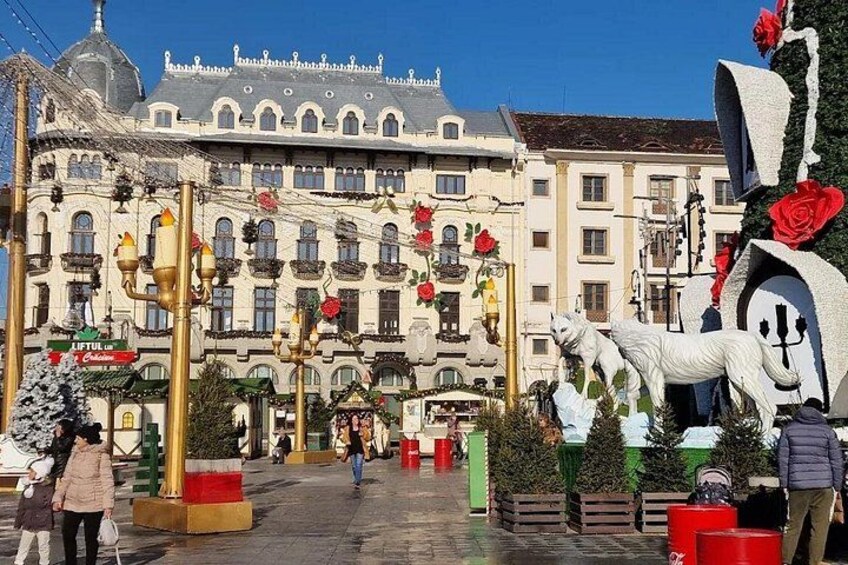 A street with a large building, street lamps, and a statue. 3