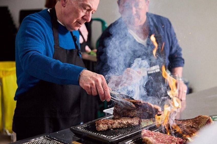 A person grilling meat on a barbecue. 1