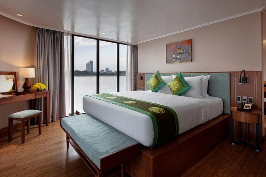 Habitación de hotel con una cama grande, un escritorio, una silla y vista al agua. 4