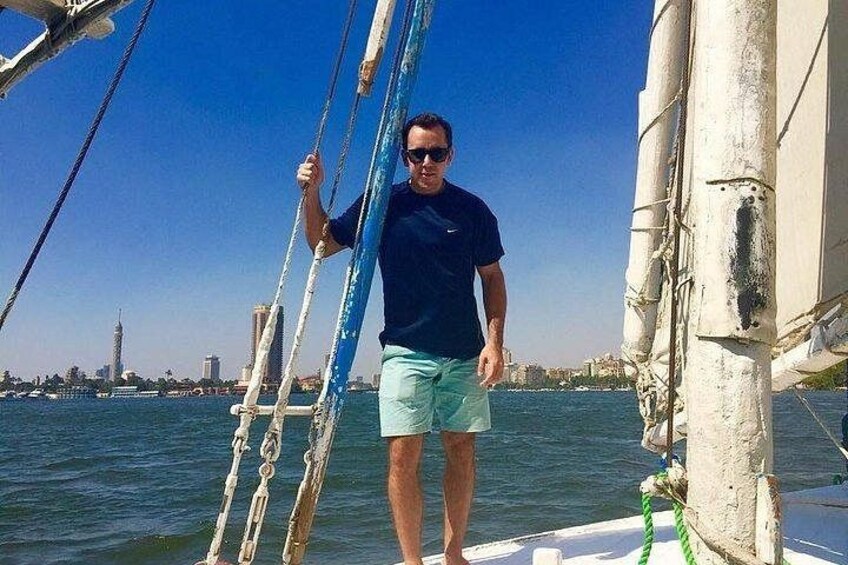 A person on a sailboat with a city skyline in the background. 2