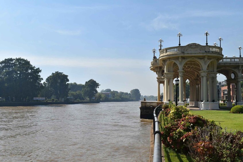 A river with a bridge, a gazebo, and greenery along the banks. 3