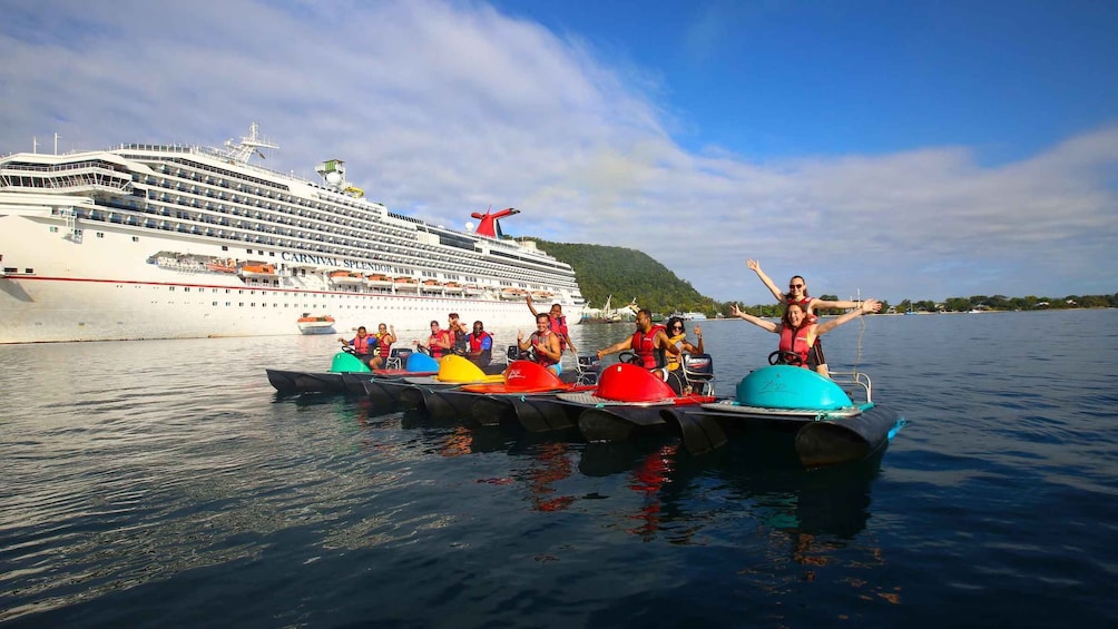 A cruise ship named 'Carnival Splendor' with passengers on a watercraft in the foreground. 1