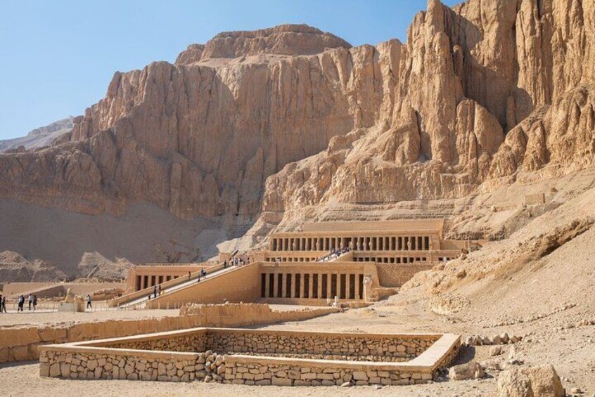 A pyramid complex with a large pyramid and smaller structures, surrounded by desert cliffs. 3