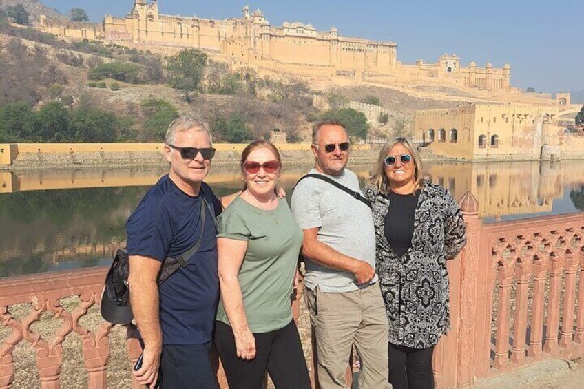Four people standing in front of a historic fort with a river in the background. 3