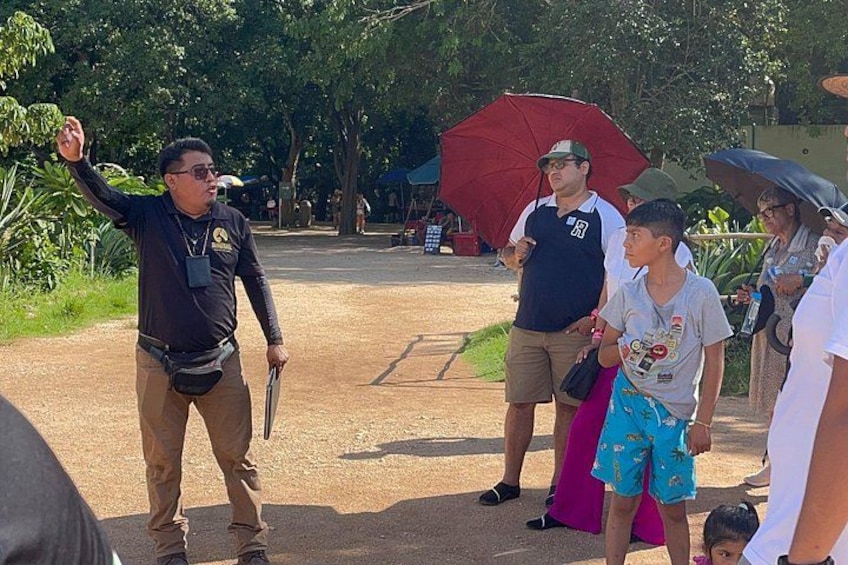 A person gesturing, a crowd, and a red umbrella in an outdoor setting. 5