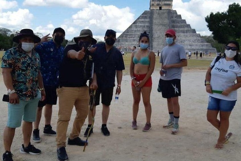 A group of people standing in front of a large pyramid-like structure. 4
