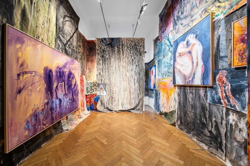An art gallery with wooden floors and colorful abstract paintings on the walls. 3