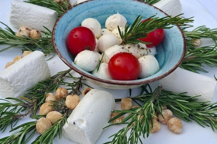 Un bol contenant des boules de mozzarella, des tomates cerises et du romarin. 2