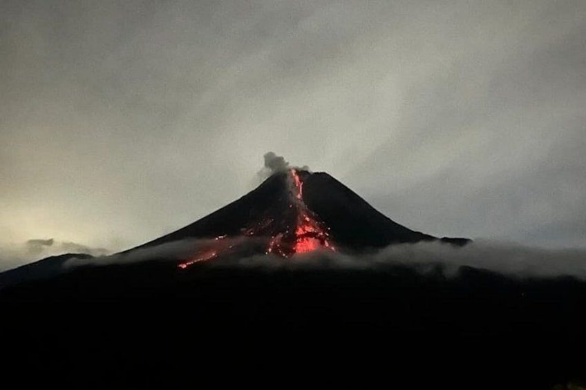A volcano with lava flowing down its side. 2