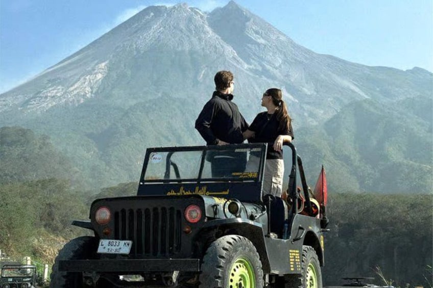 A vehicle with a driver and two passengers on a road with a mountain in the background. 5