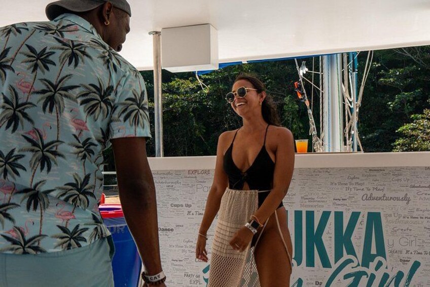 A person in a tropical print shirt and another in a black swimsuit standing near a wall with text and graphics. 3