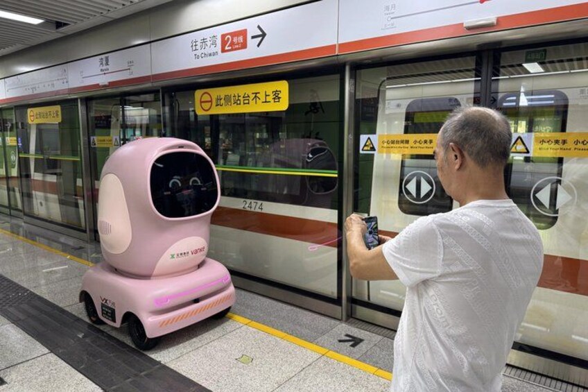Een roze robot op het perron van een metrostation. 1