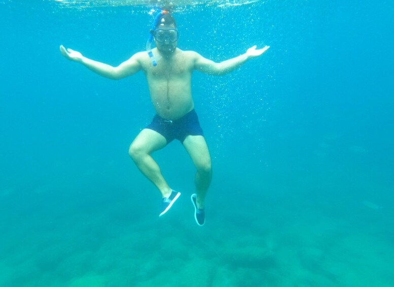 A person swimming underwater wearing a snorkel and fins. 2