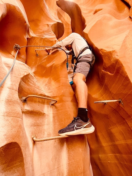 A person climbing a rock formation with ropes. 5