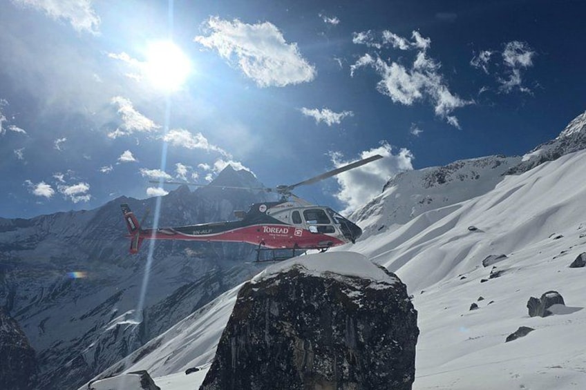 En rød helikopter med teksten 'Toread' på siden flyver over et snøklædt bjerg. 4