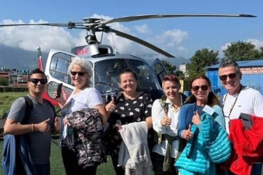 En gruppe mennesker står foran en helikopter. 5