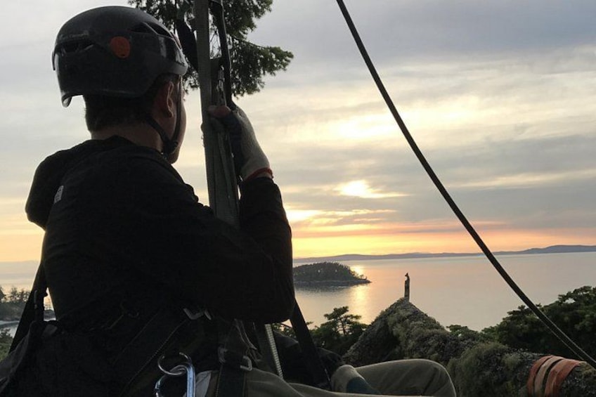 A person in a helmet and harness, preparing for a zip-lining activity. 1