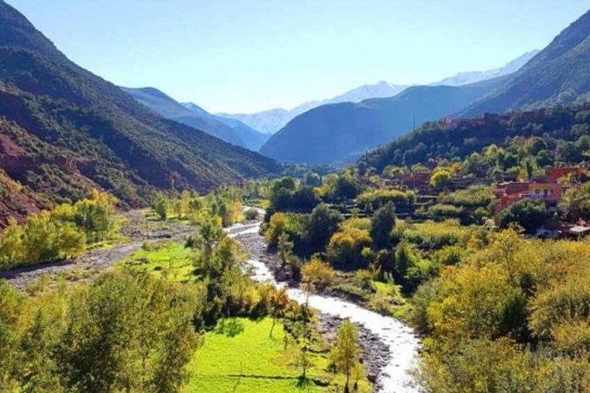 A river winding through a valley with mountains in the background and a village on the right. 5