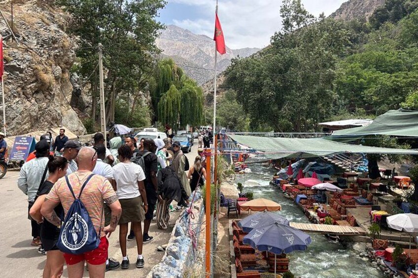 A river with boats, a crowd of people, and a mountainous landscape. 3
