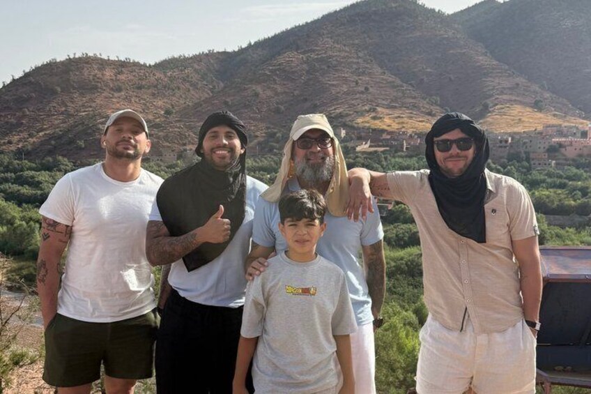 A group of people standing outdoors with a mountainous landscape in the background. 2