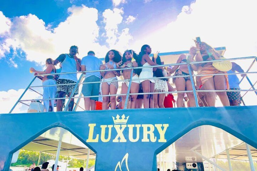 A group of people on a boat with a sign that reads 'LUXURY'. 4