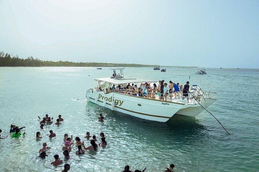 A boat named 'Prodigy' with people swimming in the water around it. 5