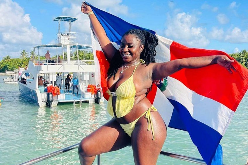 A person on a boat holding a flag, with another boat in the background. 3