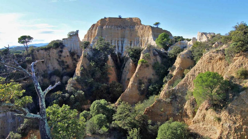 A rugged canyon landscape with prominent rock formations and sparse vegetation. 1