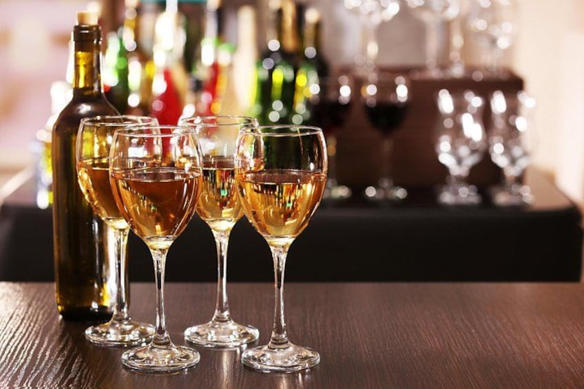 A bottle of wine and four wine glasses on a wooden surface. 5