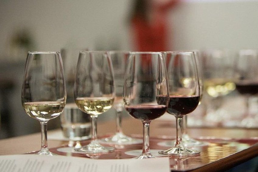 A row of wine glasses on a table with a menu in the foreground. 2