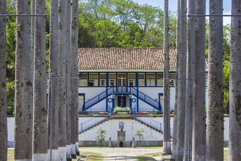 A building with a tiled roof, blue stairs, and a fountain in front. 1