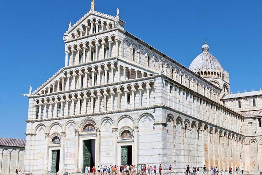 The Pisa Cathedral with its famous leaning tower, large arched windows, and a dome. 3