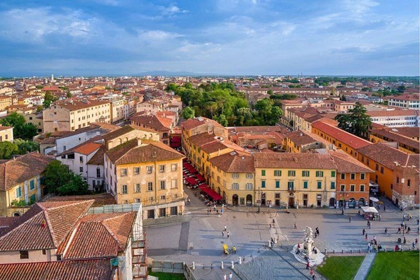 A historic square with buildings, a fountain, and a statue. 5
