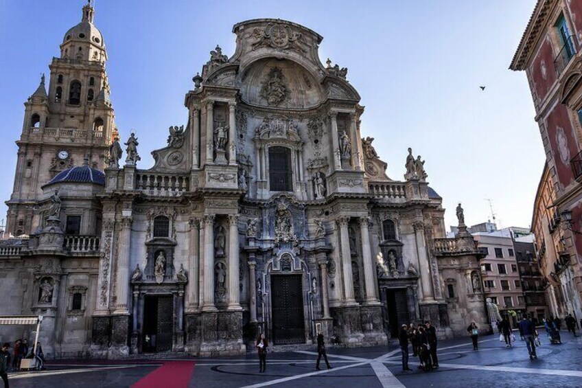 A grand historic building with intricate architecture, a prominent dome, and a red carpet in front. 3