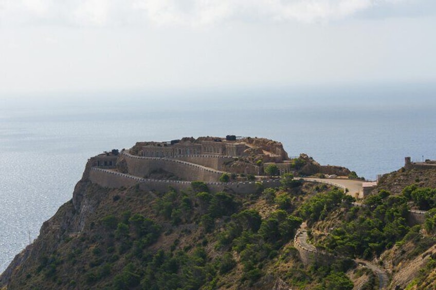 A coastal fortification with a curved wall overlooking the sea. 2