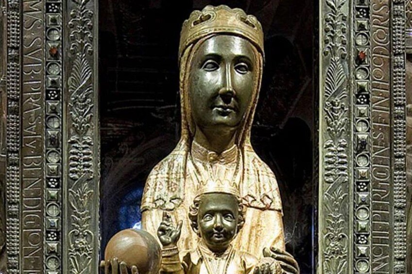 Une statue représentant une femme tenant un enfant, le tout entouré d’une décoration métallique ouvragée. 4