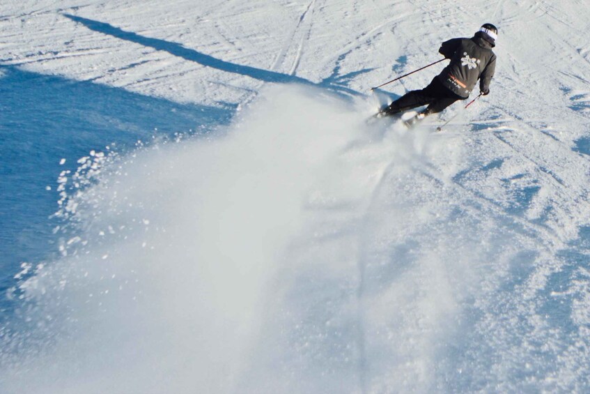 A skier carving through snow, creating a spray of snow behind them. 4