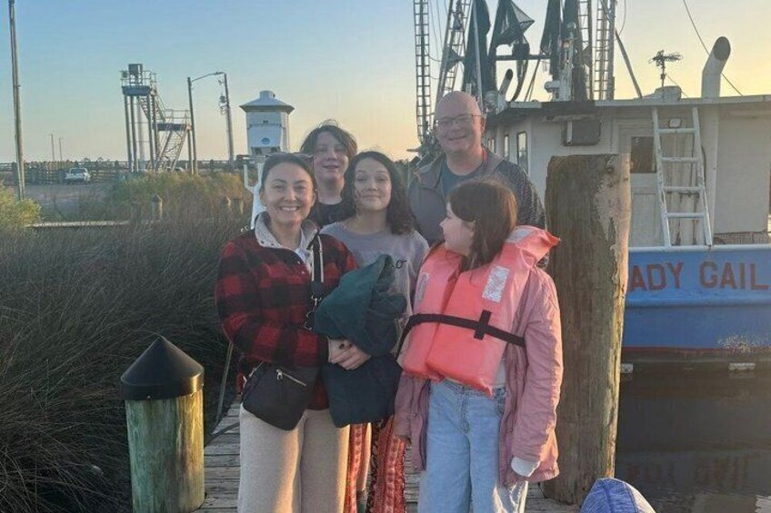 A group of people on a dock with a boat named 'Lady Gail' in the background. 3