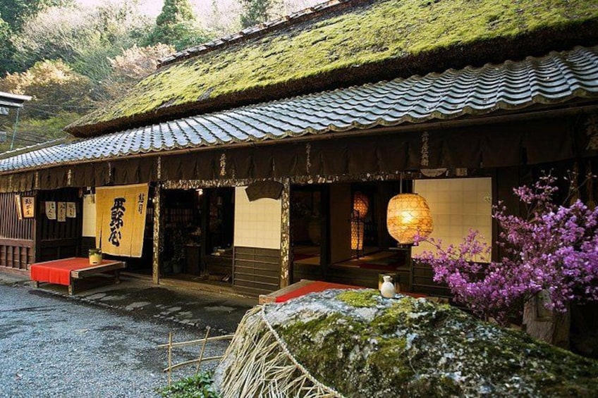A traditional Japanese building with a tiled roof, wooden structure, and a lantern. 5