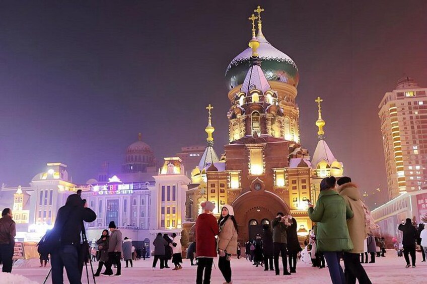 A historic building with multiple domes and spires, surrounded by people. 4