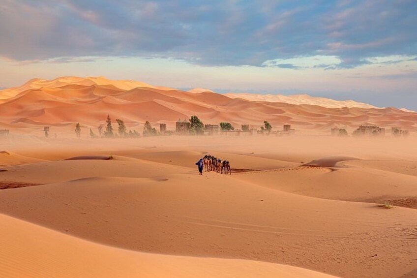 A desert landscape with sand dunes and a small group of people. 2