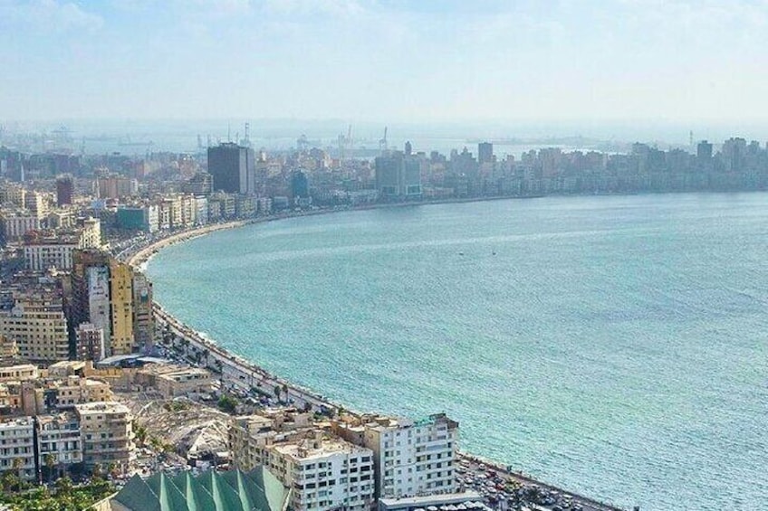 A coastal cityscape with a curved waterfront, buildings, and a distant city skyline. 2