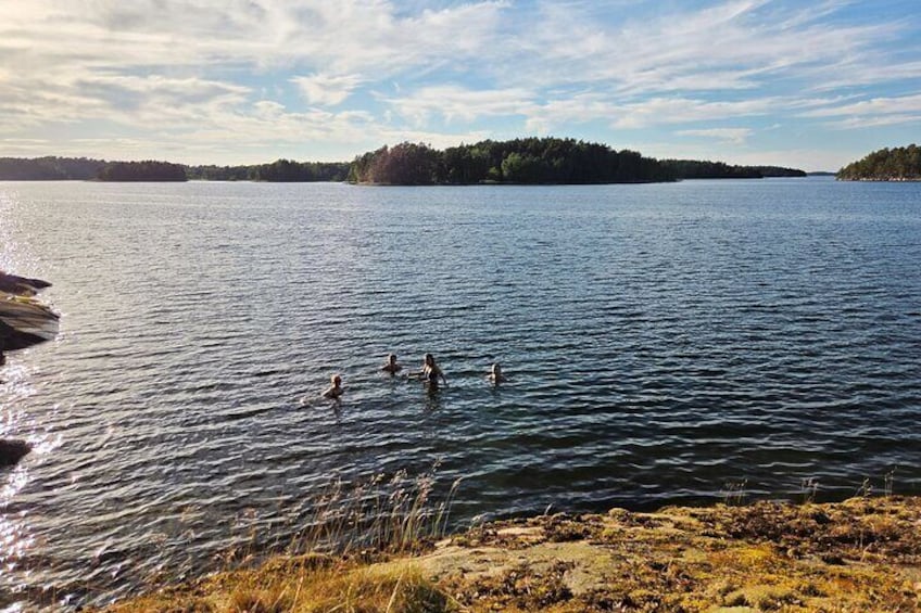 Un lago con gente nadando, rodeado de terreno boscoso. 2