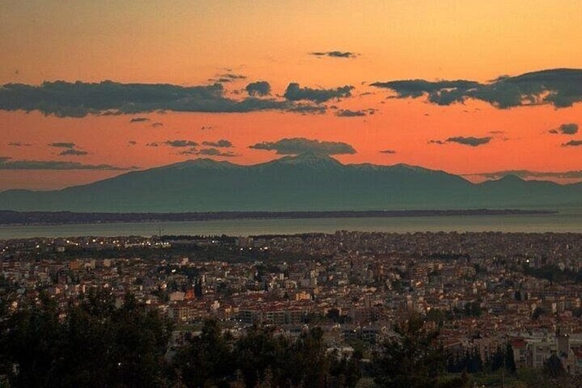 A cityscape at sunset with a mountain in the background. 3