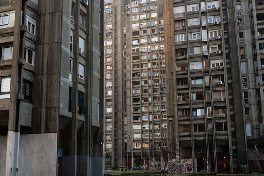Un edificio residencial alto con varios balcones y ventanas. 2