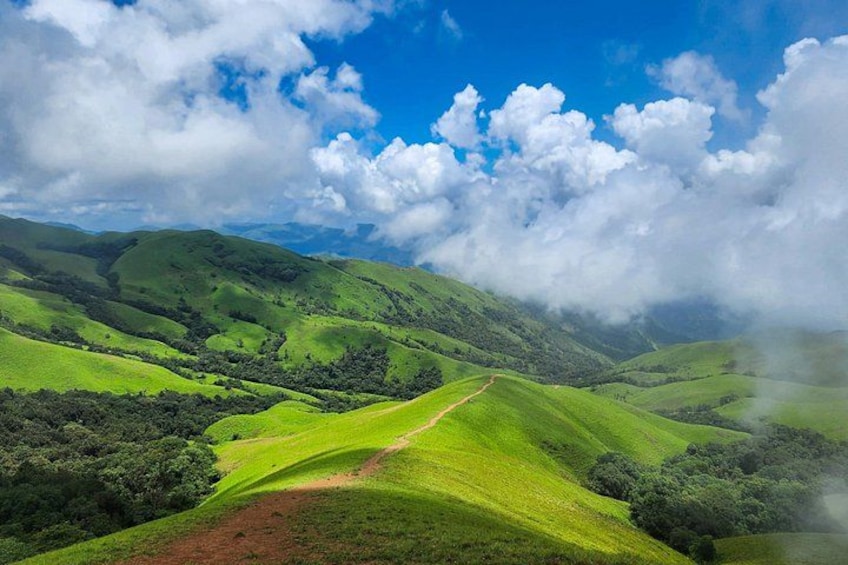 Rolling green hills, a winding path, and a partly cloudy sky. 3