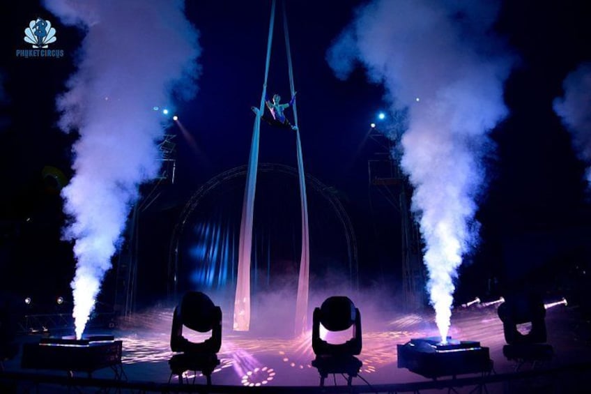 Een luchtacrobaat in een circustent, met rookeffecten. 4