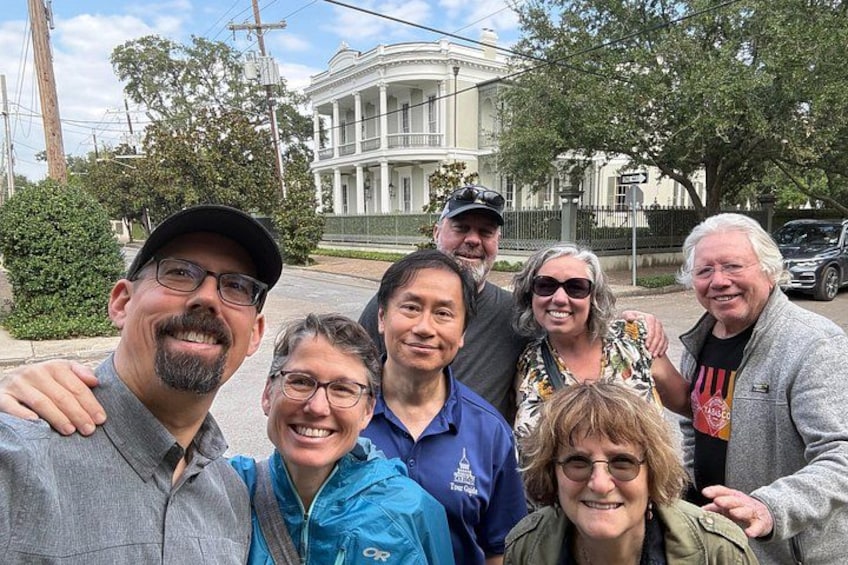 A group of people posing in front of a historic building with columns. 1