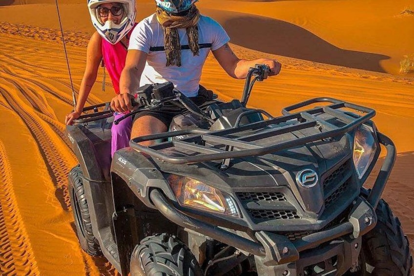 Deux personnes sur un quad dans un désert, avec des dunes de sable. 5